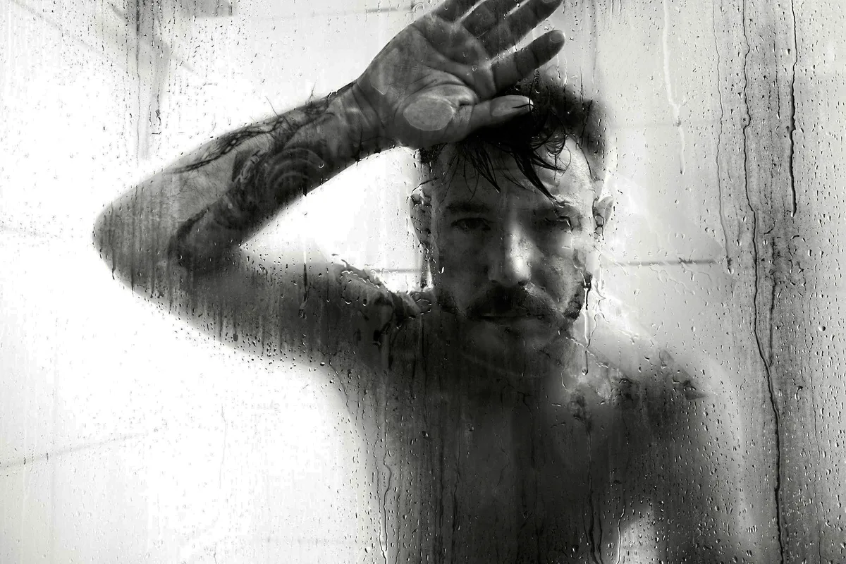 Man sieht einen Mann in der Dusche in angetrunkenem Zustand.